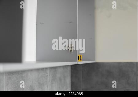 Détails des armoires de cuisine personnalisées. Cuisine modulaire grise en carton sur une variété d'étapes d'installation dans la cuisine avec un carrelage gris Banque D'Images