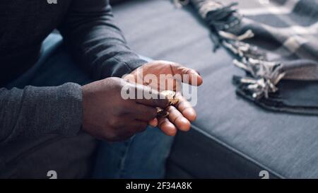 Homme noir comptant des pièces. Gros plan sur les mains de l'homme pauvre . Photo de haute qualité Banque D'Images