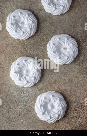 Nids de meringue vides, fond de pierre clair. Concept pour un délicieux dessert sucré. Vue de dessus. Mise au point sélective. Banque D'Images