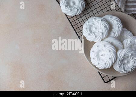 Assiette avec nids de meringue vides, fond de pierre clair. Concept pour un délicieux dessert sucré. Mise au point sélective. Vue de dessus. Banque D'Images