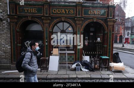 Un homme passe devant un pub à bord dans le quartier de Dublins Temple Bar, ce qui marque aujourd'hui un an jusqu'au jour où le quartier culturel a fermé en raison des fermetures de Covid-19. Date de la photo: Lundi 15 mars 2021. Banque D'Images