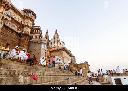 Varanasi, Uttar Pradesh, Inde : les gens s'assoient et marchent dans les ghats le long du Gange. Banque D'Images