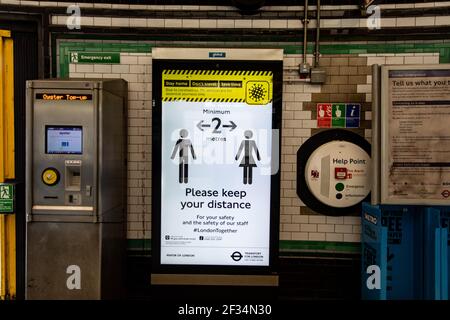 Messages à la station de métro de Tooting Broadway pour garder 2 mètres à l'écart et porter un masque lors des déplacements Banque D'Images