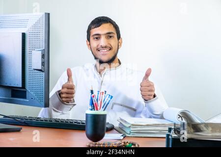 Un employé arabe musulman est heureux sur son lieu de travail Banque D'Images