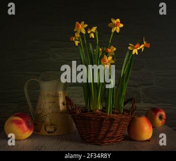 Arrangement floral dans un panier en osier et des pommes mûres. Vintage. Banque D'Images