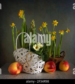 Arrangement floral dans un panier en osier et des pommes mûres. Vintage. Banque D'Images