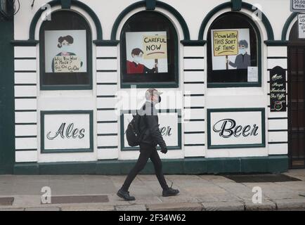 Un homme passe devant un bar dans le quartier Temple Bar de Dublin, un an jusqu'au jour où les bars et les pubs ont été fermés en raison du coronavirus. Date de la photo: Lundi 15 mars 2021. Banque D'Images