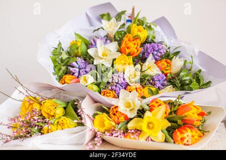 Bouquets de jacinthes bleues, tulipes jaune et orange et fleurs de jonquilles blanches, fond floral Banque D'Images