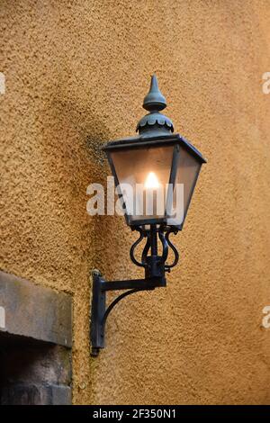 Lampadaire vintage sur mur en pierre orange Banque D'Images