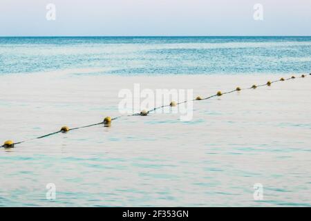 Limiter les bouées de natation sur le fond de la mer dans la soirée. Banque D'Images