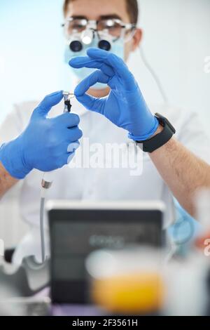 L'orthodontiste s'est concentrée sur le remplacement d'un bur de foret dentaire Banque D'Images