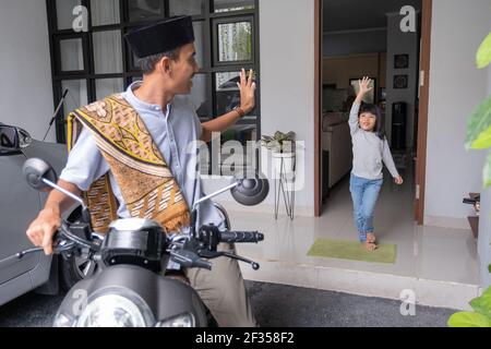 le père agite au revoir à son plus jeune à la maison avant départ à la mosquée Banque D'Images
