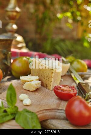 Tomates, ail, basilic et fromage parmigiano sur une ancienne table authentique. Ingrédients frais faits maison Banque D'Images