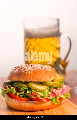 Hamburger sur le fond d'une tasse de bière. Banque D'Images