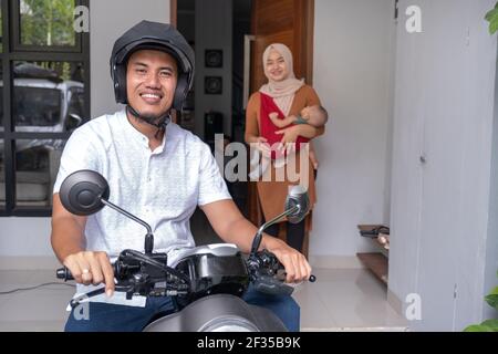 homme allant en moto au bureau avec au revoir sa femme Banque D'Images