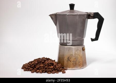 machine à café geyser ou moka pot isolé sur fond blanc avec grains de café à proximité. Banque D'Images