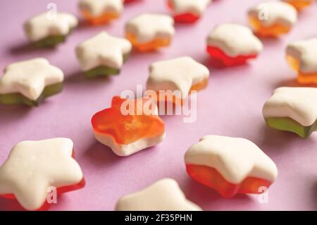 Fond de bonbons en gelée en forme d'étoile. Étoiles de marmelade de fruits sur fond rose Uni. Gros plan. Banque D'Images