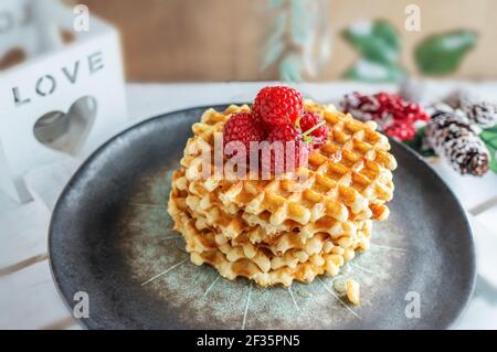 Gaufres viennoises faites maison avec framboises mûres sur une assiette de métiers d'art. Petits déjeuners faits maison. Banque D'Images