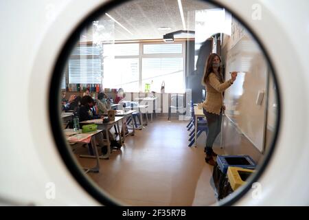 Lisbonne, Portugal. 15 mars 2021. Un professeur portant un masque donne une classe dans une école primaire à Oeiras, Portugal, le 15 mars 2021. À partir de mars 15, établissements d'enseignement pour la petite enfance, magasins à emporter, studios de beauté, librairies, commerce de voitures, Et la médiation immobilière au Portugal peut s'ouvrir après plus de deux mois de confinement pour contenir la pandémie COVID-19. Crédit: Pedro Fiuza/Xinhua/Alay Live News Banque D'Images