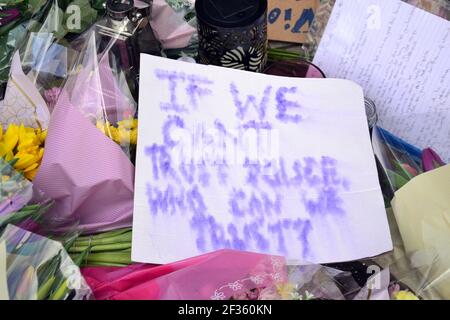 Des placardes qui font pression pour la sécurité des femmes et des fleurs à la statue d'Emmeline Pankhurst sur la place Saint-Pierre, Manchester, Angleterre, Royaume-Uni, sont partis après la vigile à la mémoire de Sarah Everard le 13 mars 2021. Un policier de la région métropolitaine de Londres a été inculpé d'enlèvement et de meurtre de Sarah Everard le 12 mars. Il a comparu devant le tribunal des magistrats de Westminster le 13 mars et a été remis en garde à vue pour comparaître devant le tribunal Old Bailey le 16 mars. Emmeline Pankhurst était le chef du mouvement des suffragettes au Royaume-Uni. La statue de bronze a été sculptée par Hazel Reeves. Banque D'Images