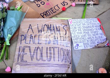 Des placardes qui font pression pour la sécurité des femmes et des fleurs à la statue d'Emmeline Pankhurst sur la place Saint-Pierre, Manchester, Angleterre, Royaume-Uni, sont partis après la vigile à la mémoire de Sarah Everard le 13 mars 2021. Un policier de la région métropolitaine de Londres a été inculpé d'enlèvement et de meurtre de Sarah Everard le 12 mars. Il a comparu devant le tribunal des magistrats de Westminster le 13 mars et a été remis en garde à vue pour comparaître devant le tribunal Old Bailey le 16 mars. Emmeline Pankhurst était le chef du mouvement des suffragettes au Royaume-Uni. La statue de bronze a été sculptée par Hazel Reeves. Banque D'Images