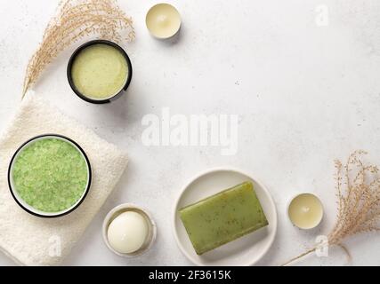 spa avec sel de mer aromatique, gommage, savon à base de plantes et serviettes de bain sur fond de pierre blanche avec bougies. vue sur le dessus, espace pour les copies Banque D'Images