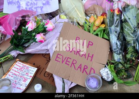 Des placardes qui font pression pour la sécurité des femmes et des fleurs à la statue d'Emmeline Pankhurst sur la place Saint-Pierre, Manchester, Angleterre, Royaume-Uni, sont partis après la vigile à la mémoire de Sarah Everard le 13 mars 2021. Un policier de la région métropolitaine de Londres a été inculpé d'enlèvement et de meurtre de Sarah Everard le 12 mars. Il a comparu devant le tribunal des magistrats de Westminster le 13 mars et a été remis en garde à vue pour comparaître devant le tribunal Old Bailey le 16 mars. Emmeline Pankhurst était le chef du mouvement des suffragettes au Royaume-Uni. La statue de bronze a été sculptée par Hazel Reeves. Banque D'Images