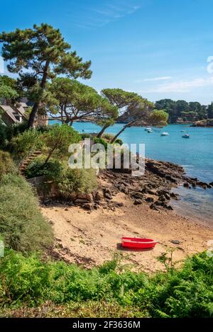 Bateau rouge dans une petite plage de l'île de Bréhat dans les Côtes d'Armor, Bretagne, France Banque D'Images