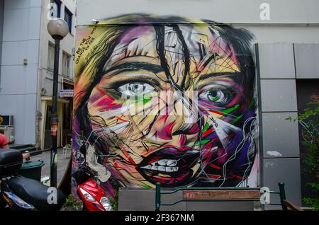 Femme face graffiti dessin sur une façade d'un bâtiment. Image très nette et colorée du visage d'une jeune femme aux yeux gris bleus. Banque D'Images