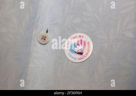 Londres, Royaume-Uni. 14 mars 2021. Un récipiendaire londonien du vaccin contre le coronavirus Astra-Zenica porte un autocollant « J'ai eu ma vaccination contre le covid » sur une chemise bleue pour homme. Credit: Anna Watson/Alay Live News Banque D'Images