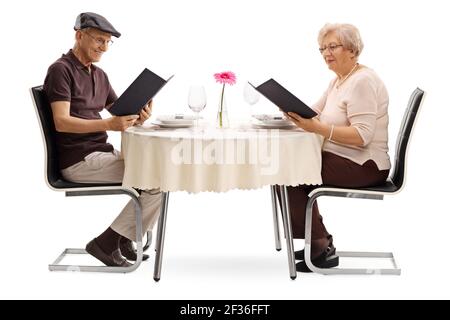 Un couple âgé dans un restaurant lisant les menus isolés arrière-plan blanc Banque D'Images