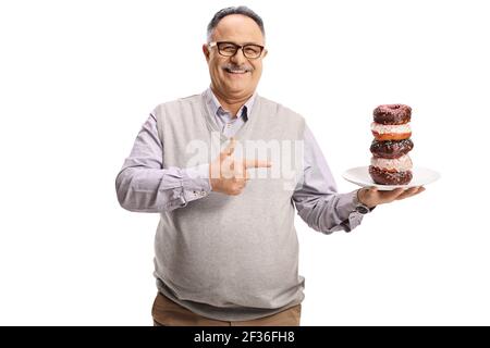 Heureux homme mature tenant une assiette de beignets de chocolat et pointage isolé sur fond blanc Banque D'Images