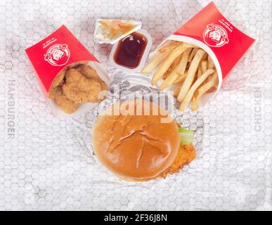 Sandwich au poulet Spicy de Wendy's sur Wrapper avec nuggets de poulet, sauce au barbecue et frites aka Chips Banque D'Images