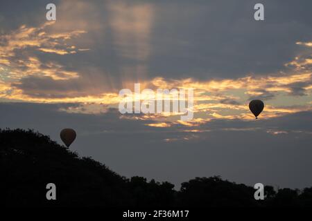 BAGAN, NYAUNG-U, MYANMAR - 2 JANVIER 2020 : deux ballons à air chaud dans le ciel au lever du soleil tôt le matin, par une journée nuageux Banque D'Images
