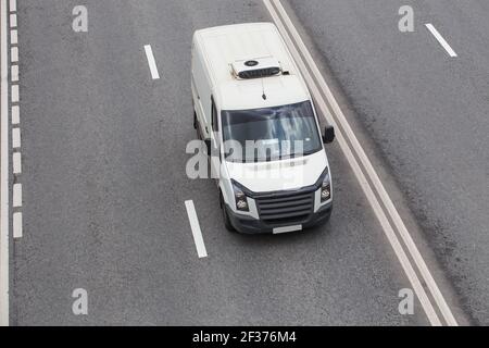 Minibus blanc va sur la ville street Banque D'Images
