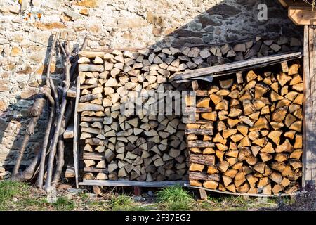 Piles de bois de chauffage empilées devant le mur en pierre, Banfalva, Sopron, Hongrie Banque D'Images