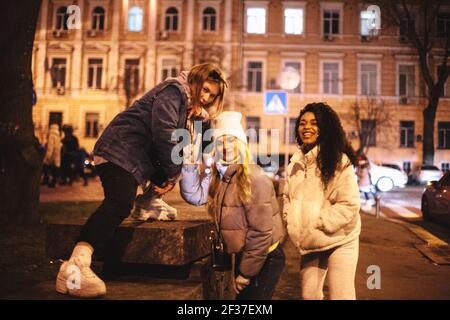 De joyeuses amies qui s'amusent en ville la nuit Banque D'Images