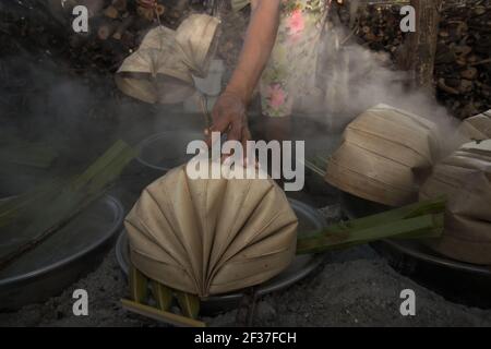 Une femme qui fait bouillir la sève du palmier pour faire du sucre de palmier, une autre source de revenu pour les villageois vivant à l'île de Rote, en Indonésie. Banque D'Images