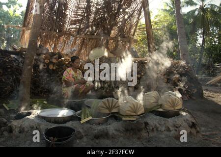 Une femme qui fait bouillir la sève de palmier pour faire du sucre de palmier dans le village d'Oehandi, île de Rote, Indonésie. Banque D'Images