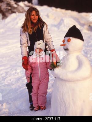 Filles avec bonhomme de neige, St.Anton (Sankt Anton am Arlberg), Tyrol, Autriche Banque D'Images