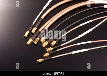 De nombreux câbles coaxiaux de radiofréquence pour les mesures isolées sur le arrière-plan sombre Banque D'Images