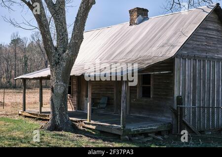 Ancien chalet en bois de pionnier abandonné avec une véranda couverte, dans la campagne de l'Alabama, États-Unis. Banque D'Images