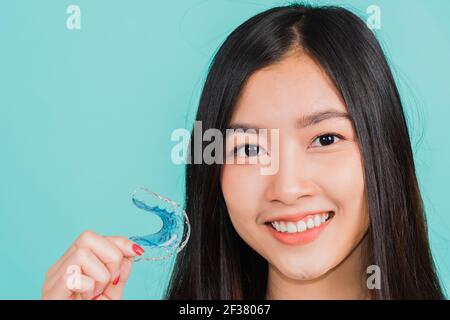 Portrait jeune asiatique belle femme souriante tenant des pièces de retenue orthodontiques en silicone pour les dents, les dents retenir les outils après les bretelles amovibles, Orthodonont Banque D'Images