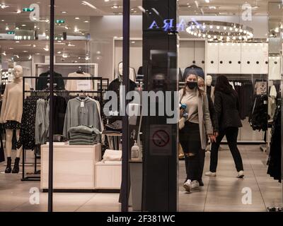 BELGRADE, SERBIE - 4 NOVEMBRE 2020: Jeune femme, marchant dans un magasin de mode, vu extérieur rfom, portant un masque respiratoire devant d Banque D'Images