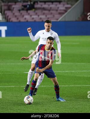 Barcelone. 16 mars 2021. Sergio Busquets (devant) de Barcelone vies avec Dani Escriche de Huesca pendant le match de football de la Ligue espagnole entre Barcelone et SD Huesca à Barcelone, Espagne, le 15 mars 2021. Credit: Xinhua/Alay Live News Banque D'Images