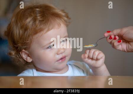 Nourrir bébé. Pas faim. Enfant refusant de manger. L'enfant n'a pas d'appétit. Un petit enfant contrarié refuse de manger de la soupe. Une alimentation saine pour les enfants. Banque D'Images