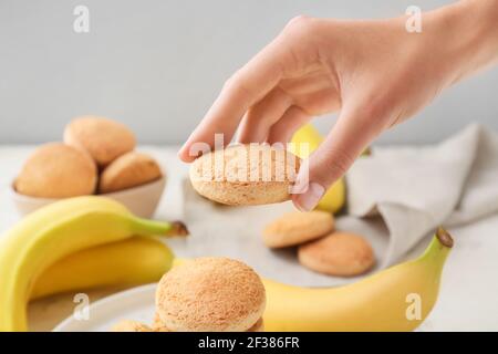 Main féminine avec délicieux biscuits à la banane, gros plan Banque D'Images