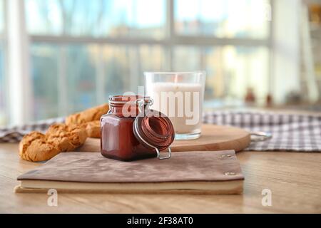 Bougie aromatique avec carnet et biscuits sur la table dans la cuisine Banque D'Images