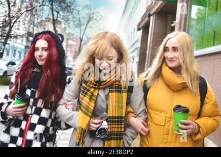 Vacances, le tourisme concept - trois jeunes filles belles marchant autour de la ville boire du café et prendre des photos Banque D'Images