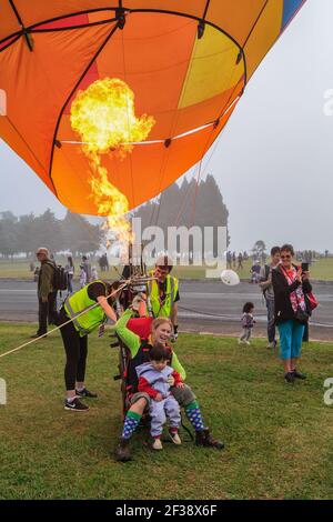 Une pilote femelle faisant la démonstration d'un « char » (montgolfière avec un siège unique) à un jeune enfant aux Balloons au-dessus du festival de Waikato, Hamilton, Nouvelle-Zélande Banque D'Images